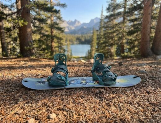 Grey and teal kids snowboard with bindings attached